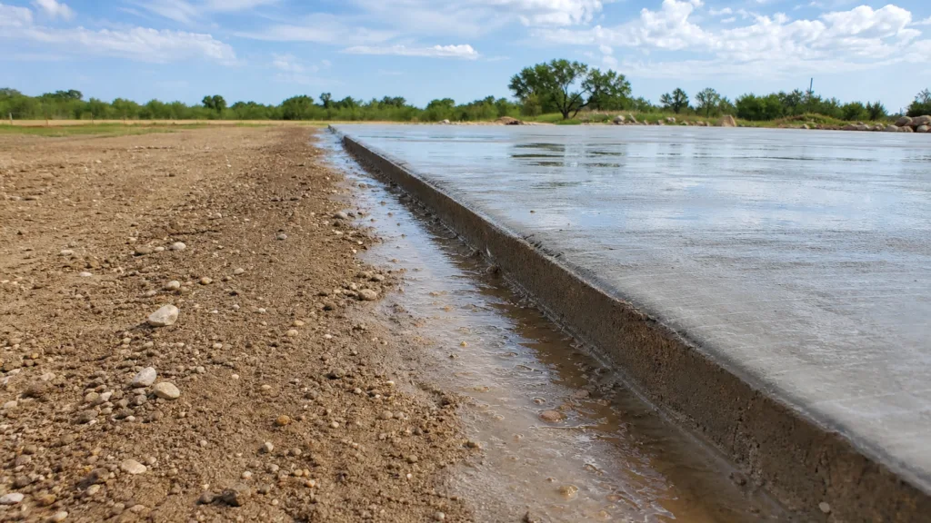 Amarillo exterior concrete after rain beside dry High Plains landscaping