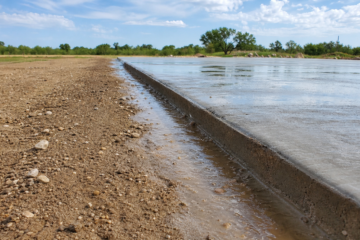 Amarillo exterior concrete after rain beside dry High Plains landscaping